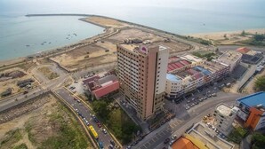 An urban area with a prominent high-rise building, a marina with boats, and a road network.