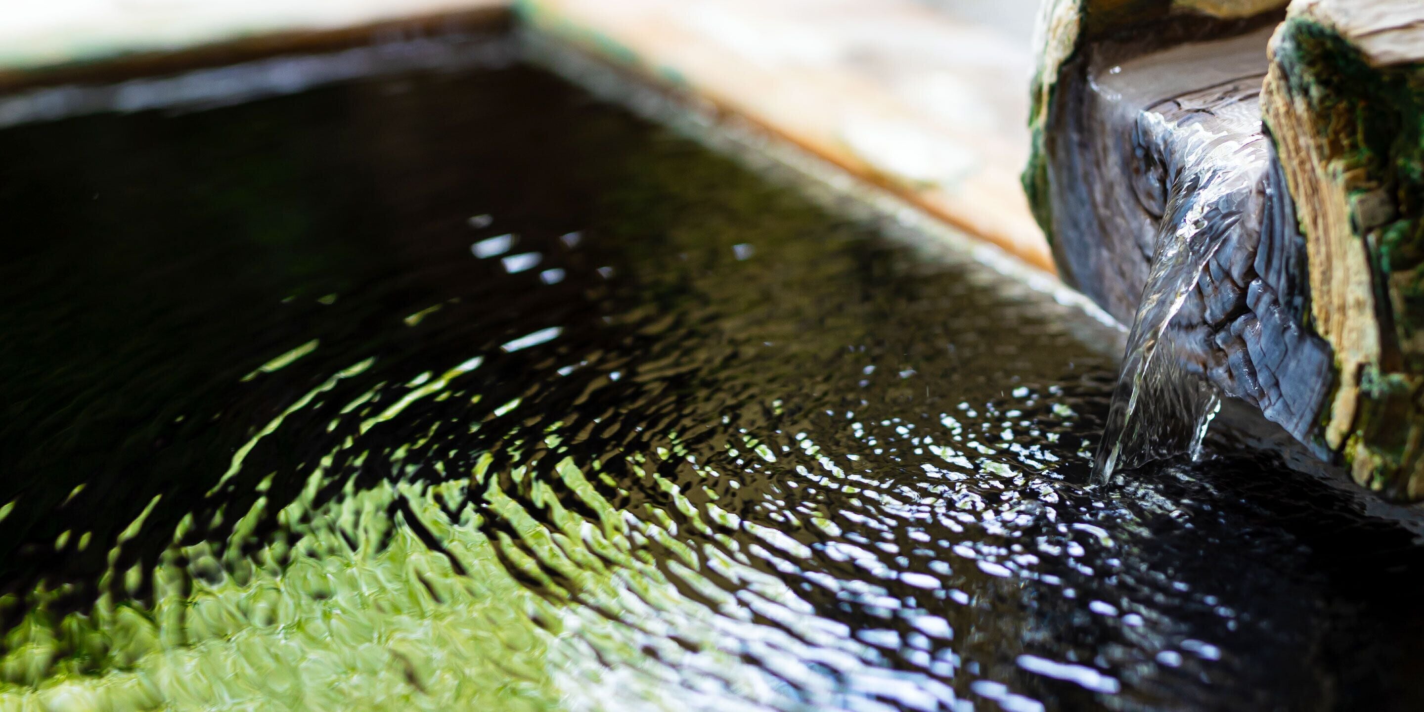 A close-up of a water feature with a wooden structure and a flowing stream.