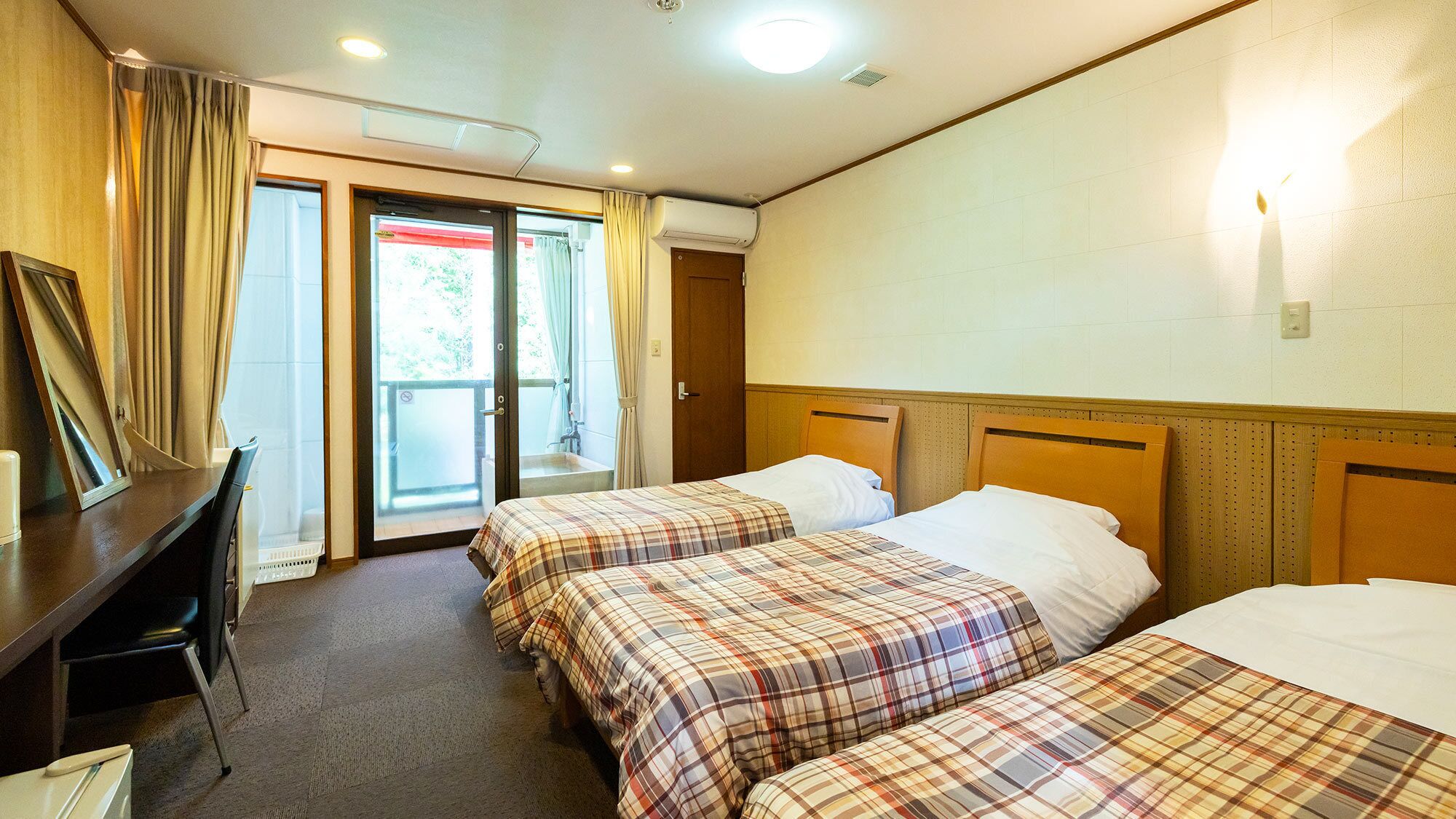 Habitación de hotel con dos camas, un escritorio y una silla.