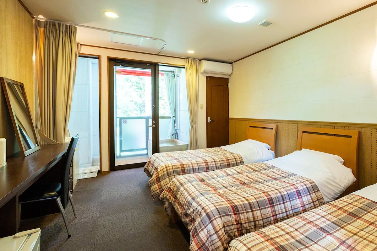 Een hotelkamer met twee bedden, een bureau en een stoel.