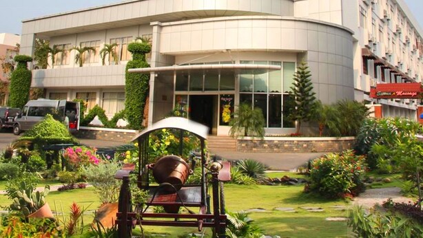A modern hotel with a curved facade, a well-maintained garden, and a visible massage parlor. - Cuu Long Hotel (Can Tho)