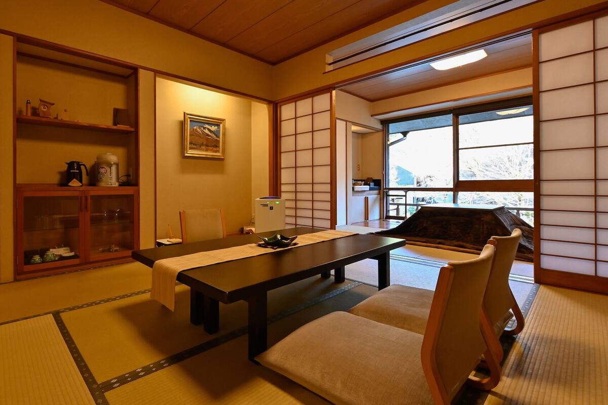A traditional Japanese room with tatami flooring, a low table, and sliding doors.