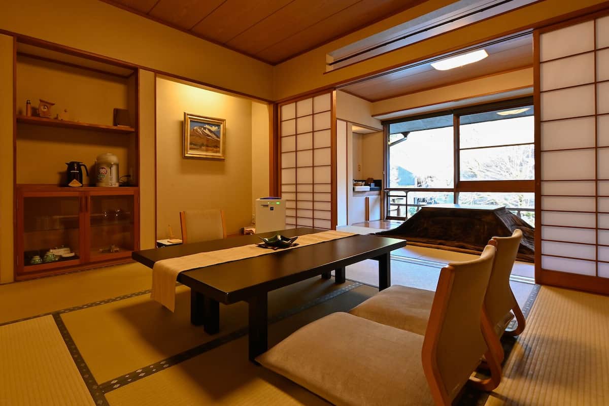Une pièce de style japonais traditionnel, avec un sol recouvert de tatamis, une table basse et des portes coulissantes.
