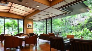Une pièce spacieuse dotée d’un plancher en bois, de grandes fenêtres et d’un plafond au design à lattes.