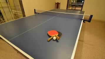 A ping pong table with a paddle and ball in the center.