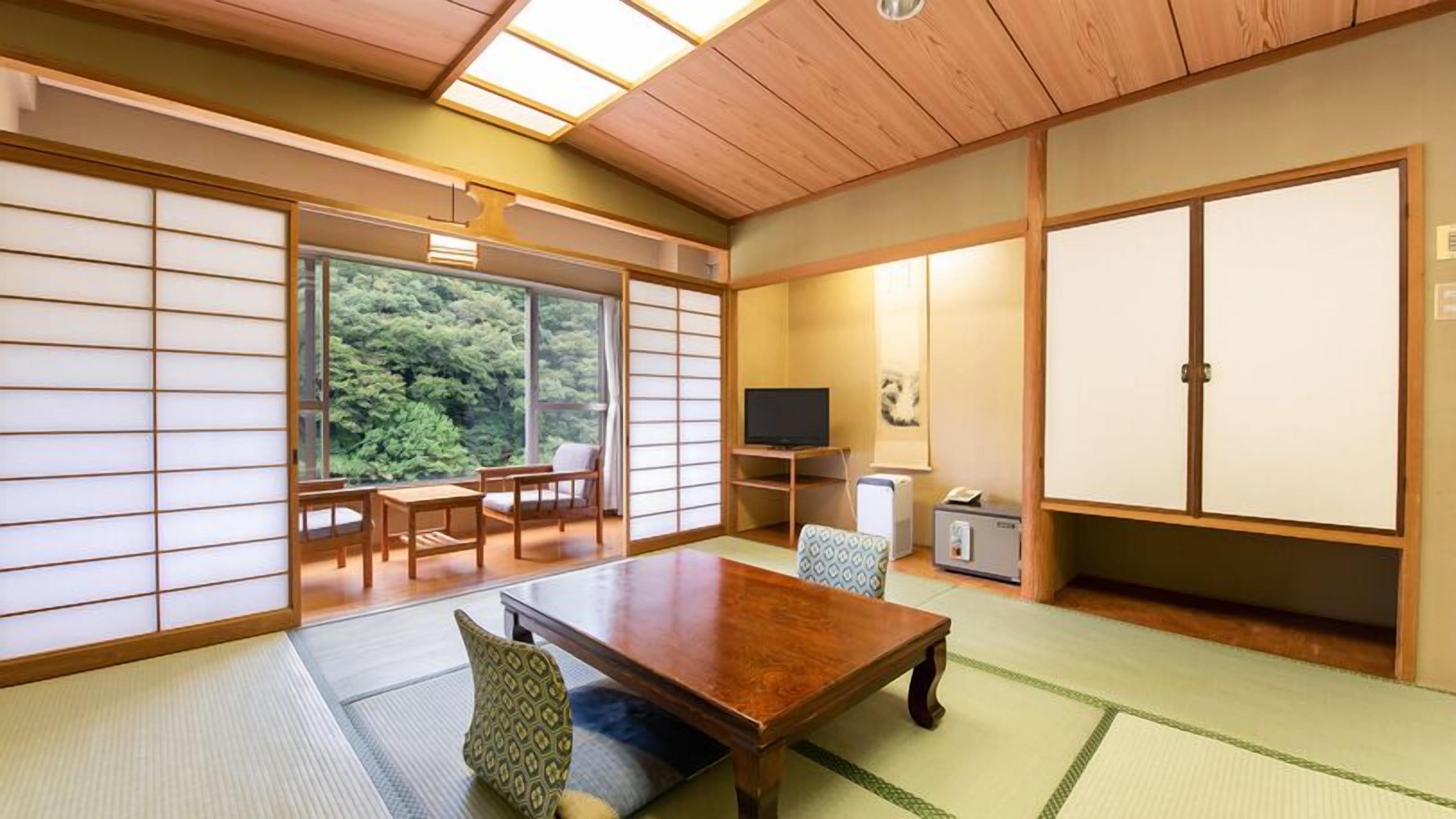 Une pièce de style japonais traditionnel, avec un sol recouvert de tatamis, une table basse et des portes coulissantes.