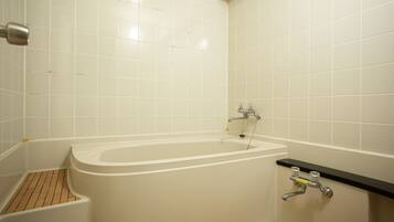 Een badkamer met een bad, een douche en een toilet.
