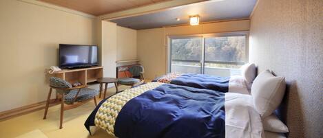 Een hotelkamer met een bed, een televisie, een bureau en een stoel.