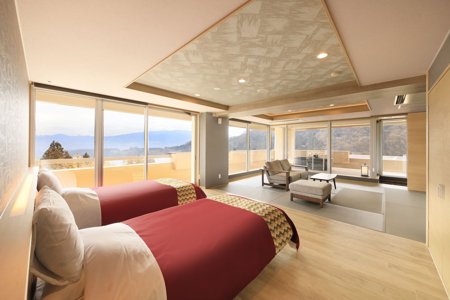 Habitació d'hotel moderna amb un llit gran, zona de seients i un balcó amb vistes.