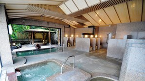 Un área de spa con un jacuzzi, una piscina y una zona de estar cubierta.