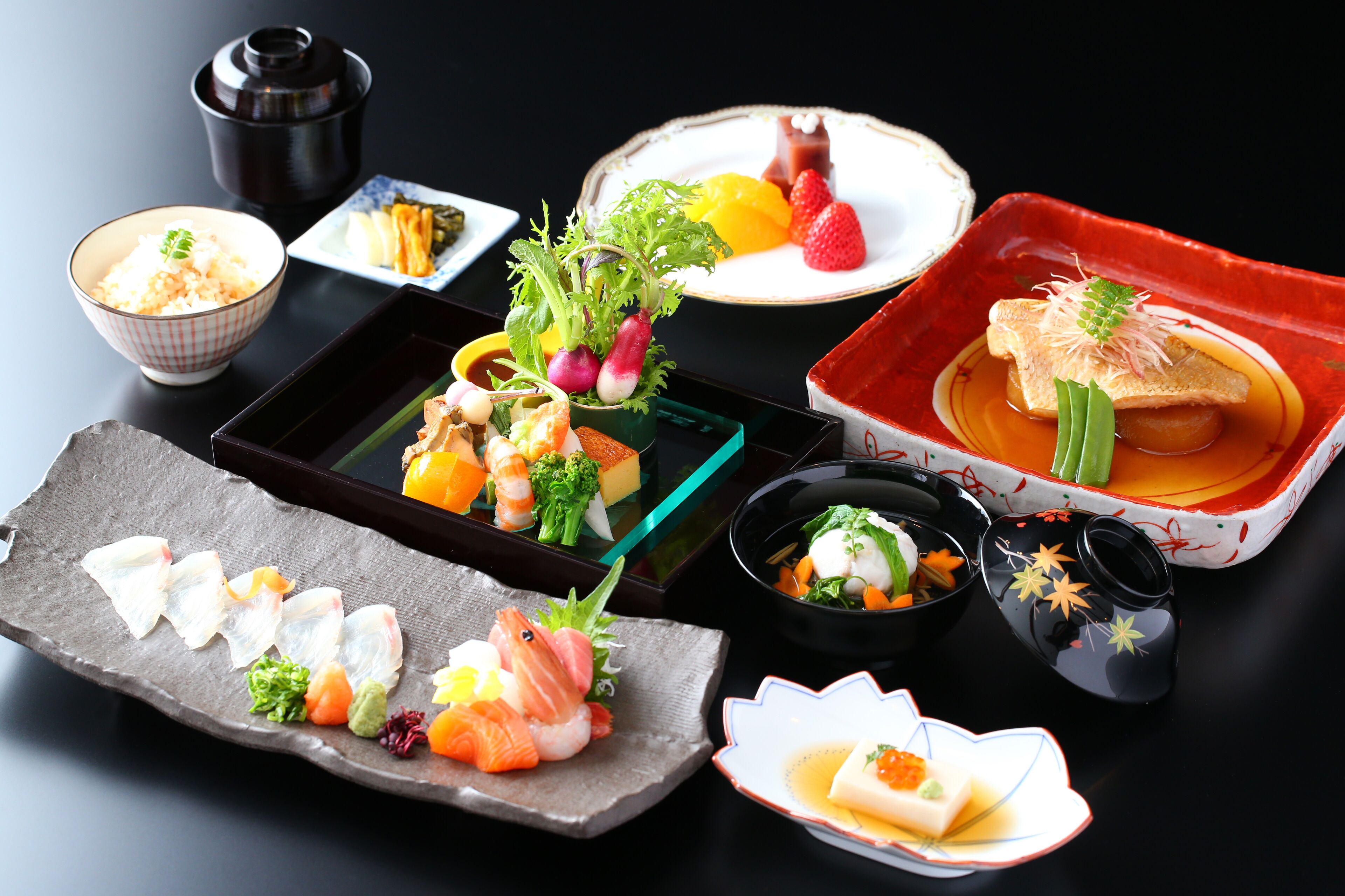 Variedad de platos japoneses sobre una mesa, incluyendo sushi, sashimi y otras exquisiteces.