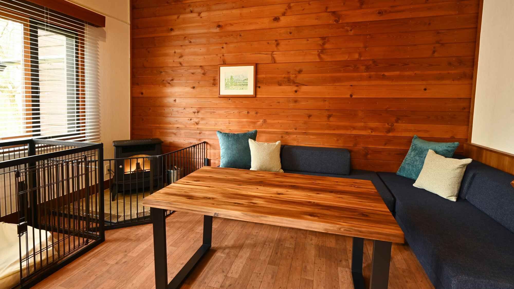 A wooden-paneled room with a sofa, a table, and a fireplace.