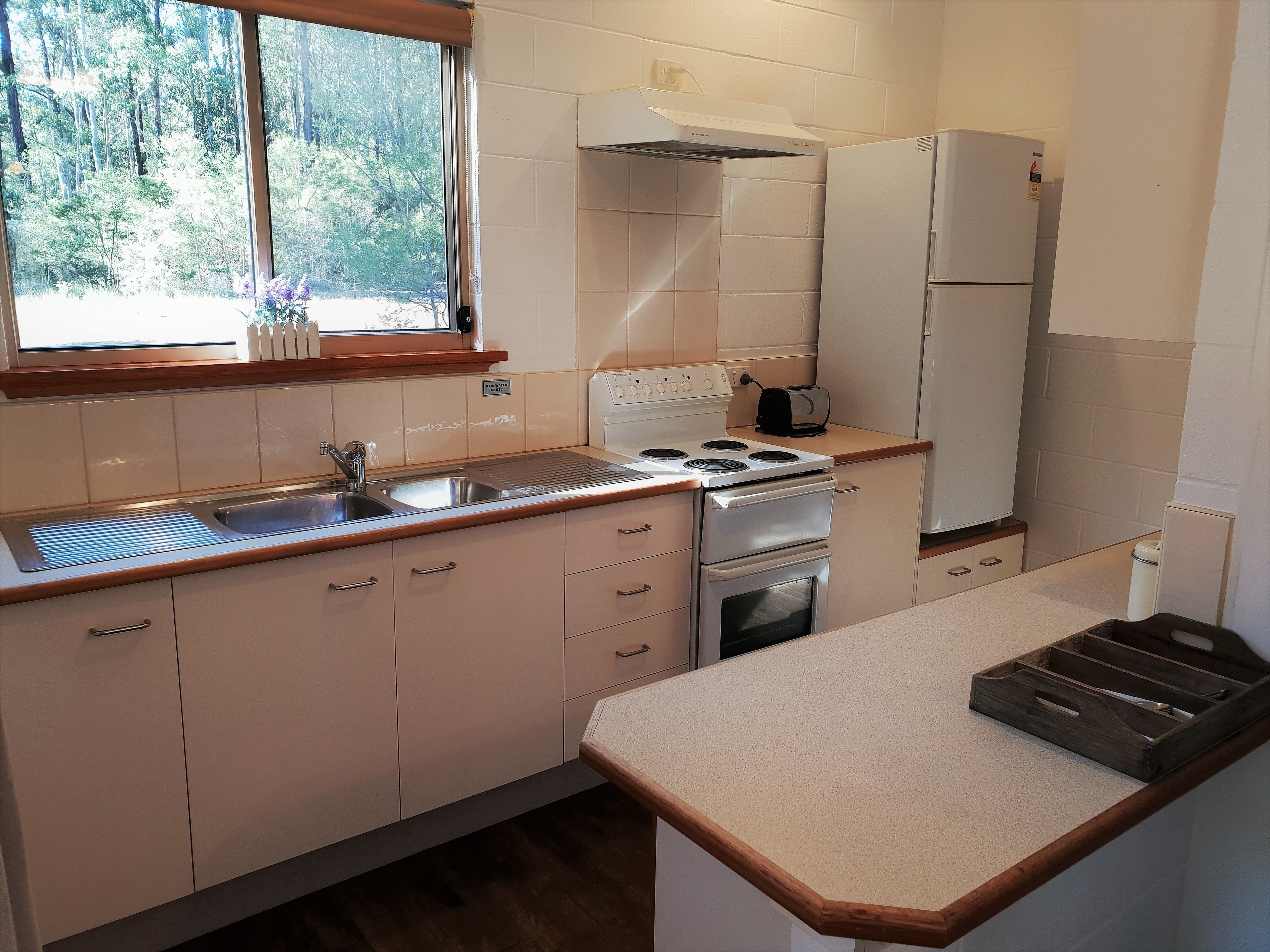 A modern kitchen with a window, stainless steel appliances, and wooden countertops.