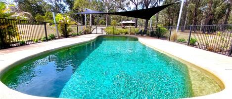 Piscine extérieure en saison, chaises longues