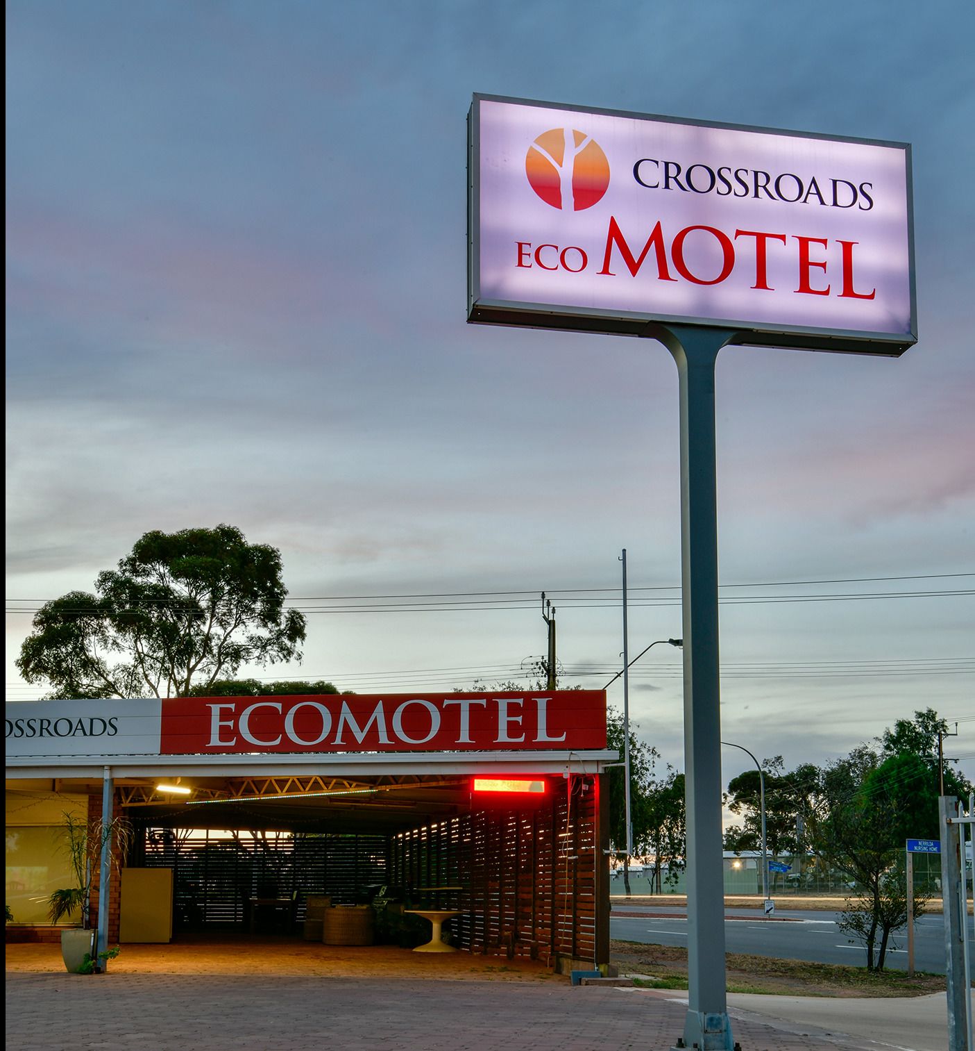 A motel sign with "Crossroads Eco Motel" and a building with a red awning labeled "Ecomotel".