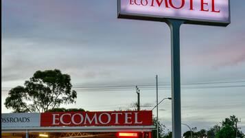 A motel sign with "Crossroads Eco Motel" and a building with a red awning labeled "Ecomotel".