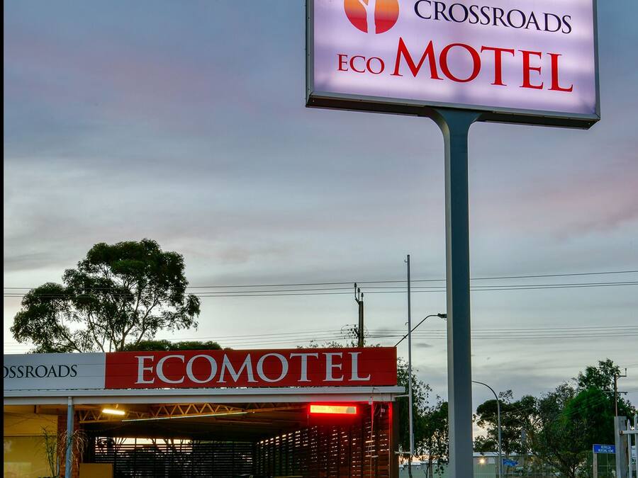 A motel sign with "Crossroads Eco Motel" and a building with a red awning labeled "Ecomotel".
