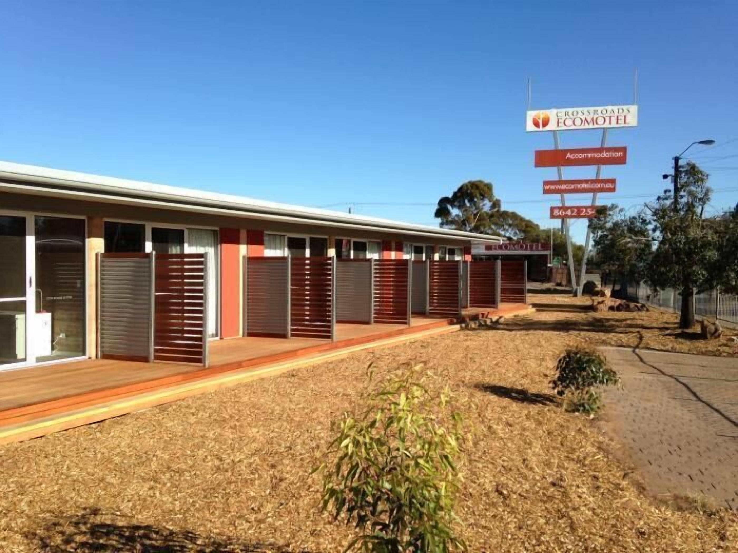 A motel with multiple rooms, a covered outdoor area, and a sign advertising accommodation.