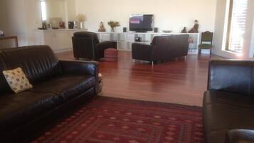 Relax in this inviting living room with a comfortable sofa, patterned rug, and a large window offering a view.
