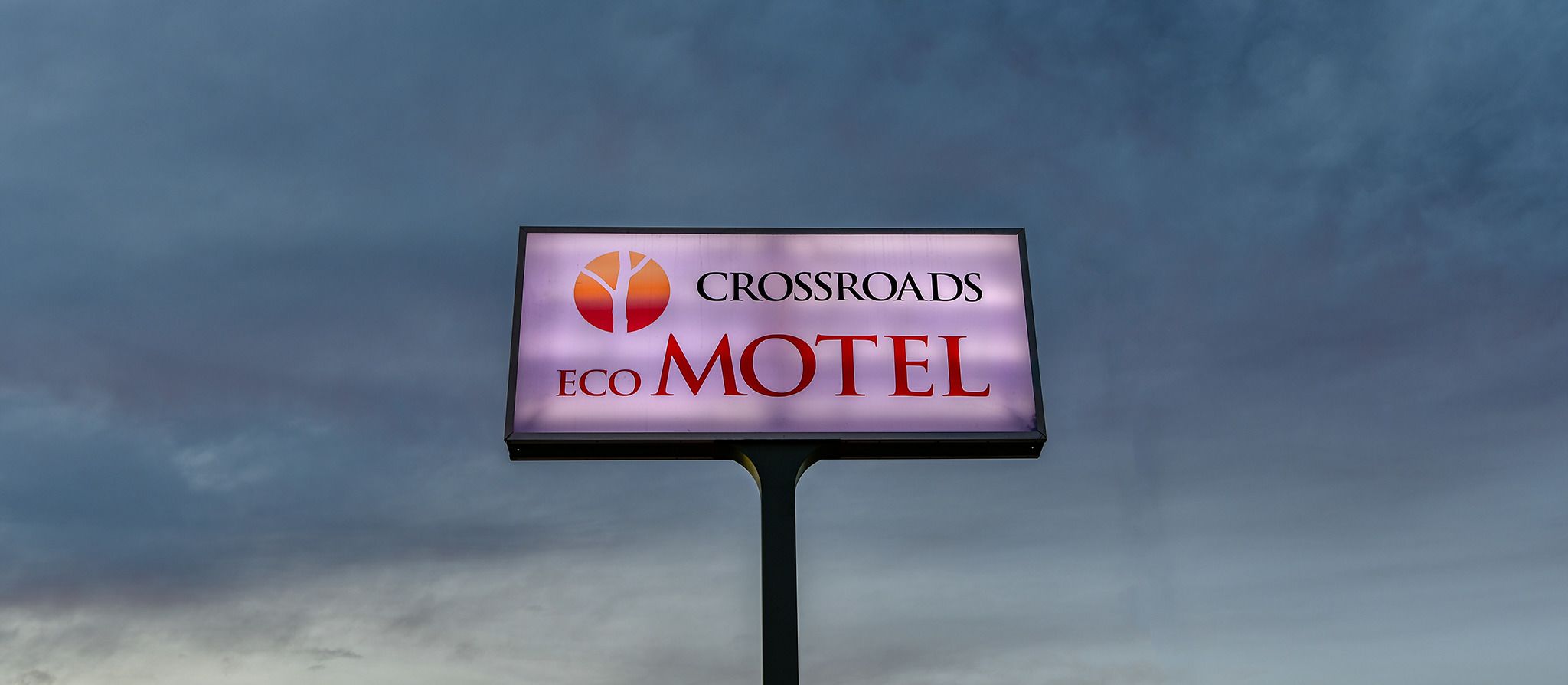 Une enseigne pour le motel Crossroads, avec un logo et le nom de l’établissement.