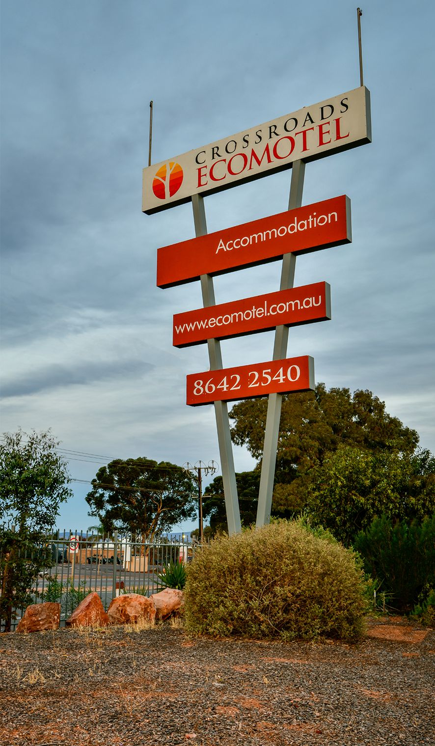 A sign for Crossroads Ecomotel with accommodation details and contact information.