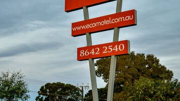 A sign for Crossroads Ecomotel with accommodation details and contact information.