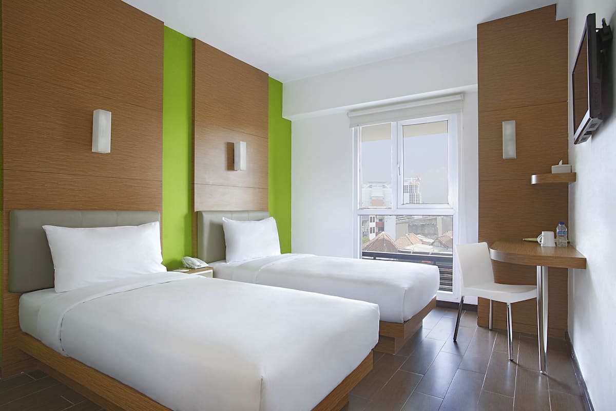 Una habitación de hotel con dos camas, un escritorio y una silla.