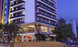 Ein mehrstöckiges Hotel mit Balkonen, großen Fenstern und einer schlichten Fassade.