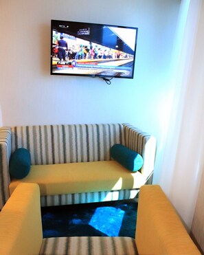 Suite, vista al océano | Área de sala de estar | Televisión de pantalla plana