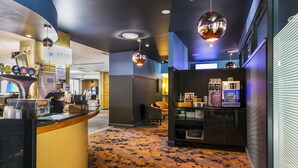 A hotel lobby with a reception desk, seating area, and coffee machines. - Toongabbie Hotel (Toongabbie)