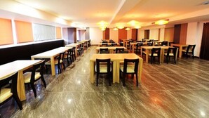 Una àrea de dinar espaiosa amb diverses taules i cadires, disposades per files.
