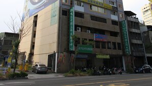 Un edifici de diverses plantes amb espais comercials a la planta baixa i habitatges a la part superior.