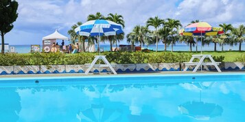 Una piscina al aire libre, sillones reclinables de piscina