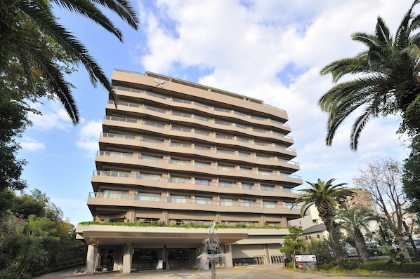 A multi-story hotel with a flat roof, balconies, and a covered entrance. - Hotel Harvest Ito (Ito)