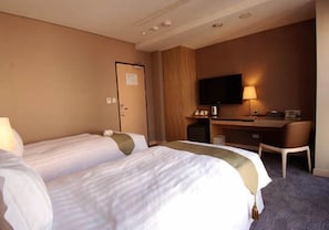 A hotel room with two beds, a desk, a chair, a TV, and a lamp. - Leesing Hotel-Qixian (Kaohsiung)