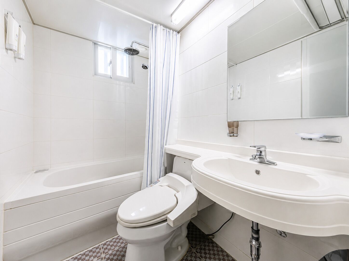 A modern bathroom with a bathtub, toilet, and sink.