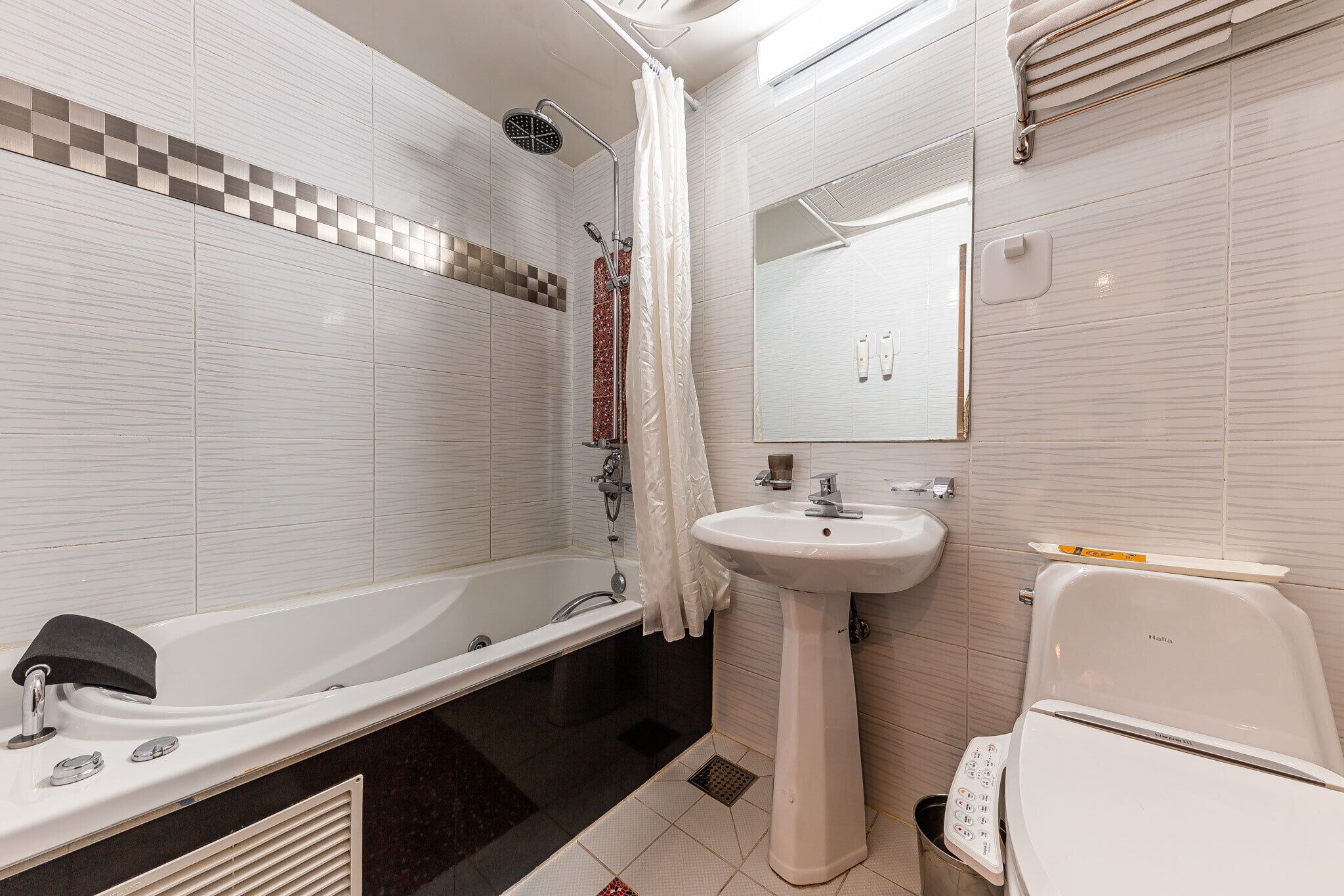 Un baño moderno con una bañera independiente, un lavabo sobre pedestal y un inodoro.