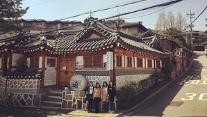A traditional Korean building with wooden architecture, a stone base, and a signboard. - Friendly DH Naissance Hotel by Mindrum Group (Seoul)