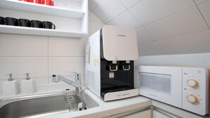 A kitchen with a water dispenser, a sink, and a microwave. - K-Guesthouse Dongdaemun Premium 2 (Seoul)