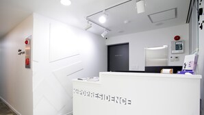 A reception desk with "KPOPRESIDENCE" signage, a "STAFF ONLY" door, and a security camera. - K-Guesthouse Dongdaemun Premium 2 (Seoul)