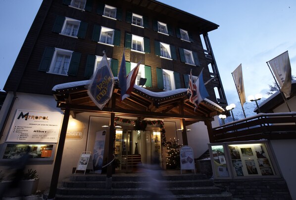 Vista frontal de la propiedad por la tarde o noche