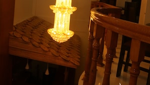 Una escalera con balaustres de madera y un candelabro con varias luces.