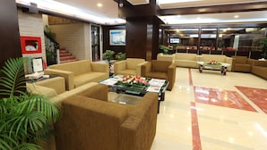 A lobby with sofas, a coffee table, and a staircase. - Nascent Gardenia Baridhara (Dhaka)