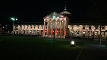 A classical building with a central dome and columns, illuminated at night.