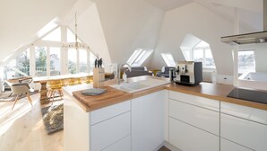 A modern kitchen with a large island, skylights, and a view of the outdoors. - GL Apartmenthouse (Wiesbaden)