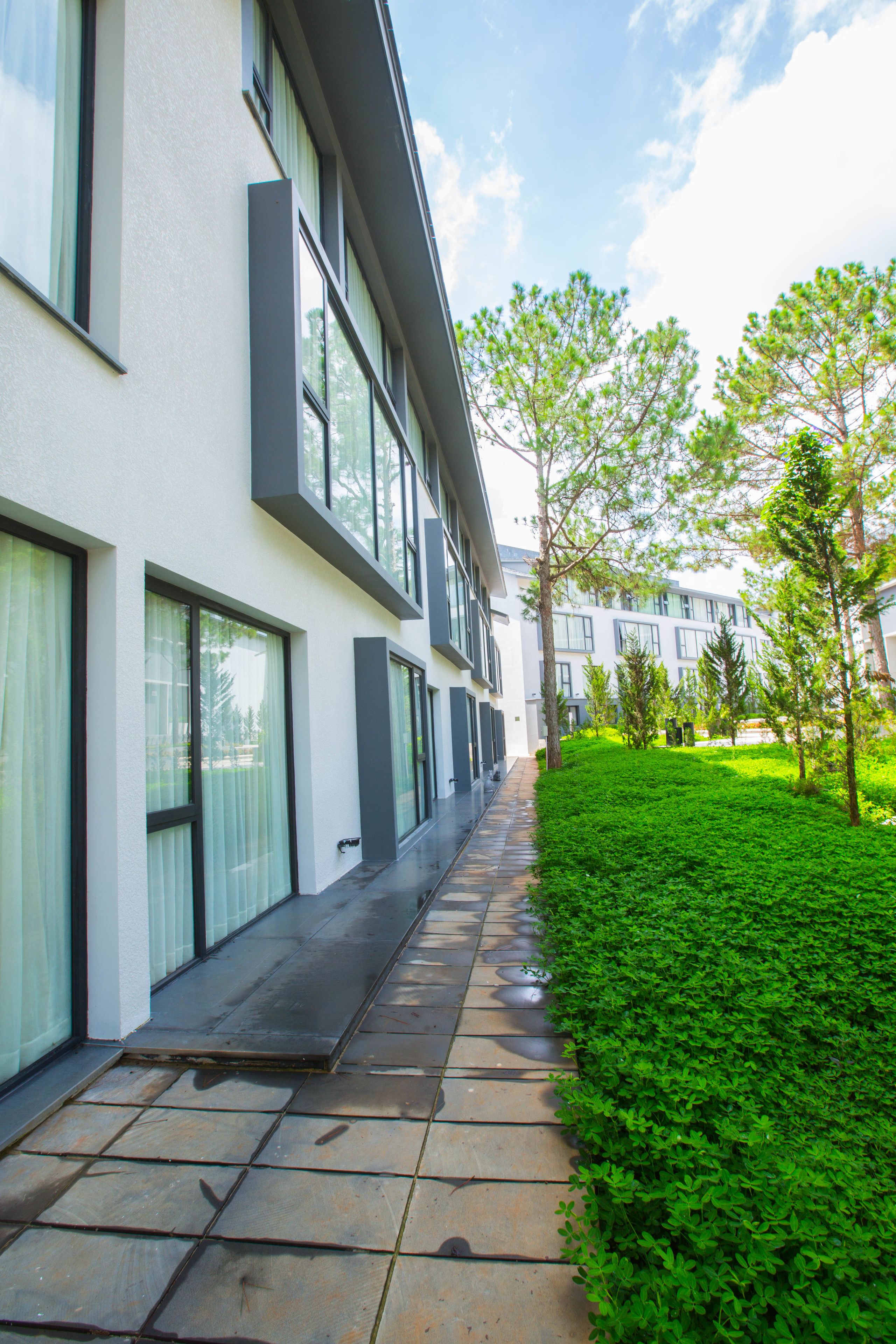 A modern building with large windows and a well-maintained green lawn.