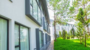 A modern building with large windows and a well-maintained green lawn.