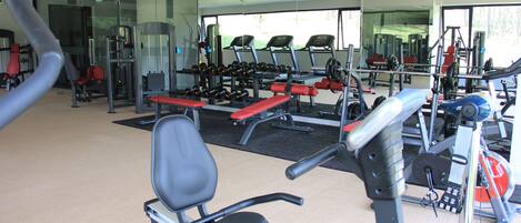 A gym with exercise equipment, including treadmills, dumbbells, and weight machines.
