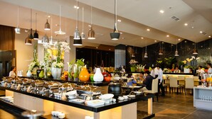 A buffet area with various food stations, a central island with seating, and hanging pendant lights. - Terracotta Hotel & Resort Dalat (Xuan Huong - Da Lat)