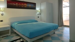 A bedroom with a bed, a wardrobe, a nightstand, and a wall-mounted lamp. - B&B Mediterraneo Mare e Sole (Palma di Montechiaro)